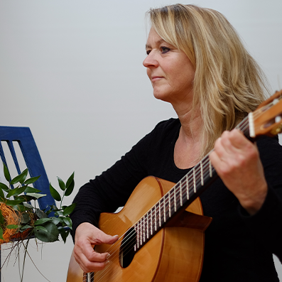 teacher playing guitar with music notes